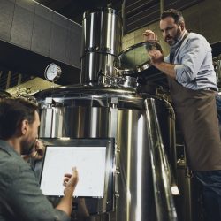 male-brewers-in-aprons-working-with-tanks-and-industrial-equipment-at-the-brewery.jpg